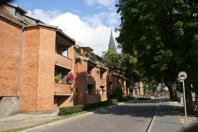 an empty street with a brick building and a church at Old Town Apartment with a separate entrance in Kaunas