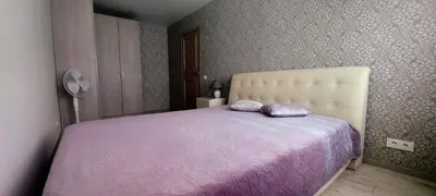 a bedroom with a large bed with a purple blanket at Apartment next to Cathedral of Saints Peter & Paul in Šiauliai