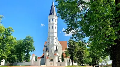 a church with a steeple on top of it at Apartment next to Cathedral of Saints Peter & Paul in Šiauliai