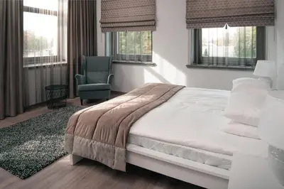 a bedroom with a bed and a chair and windows at Laurentroom Center in Ukmergė