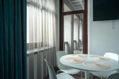 a white table and chairs in a room with a window at Laurentroom Center in Ukmergė