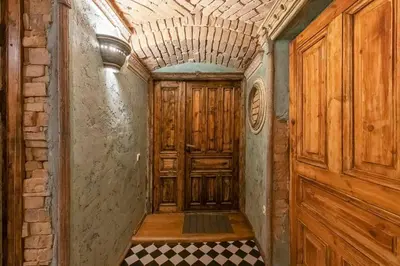 an empty hallway with a wooden door and a checkered floor at Beautiful one bedroom apartment in Vilnius old town in Vilnius