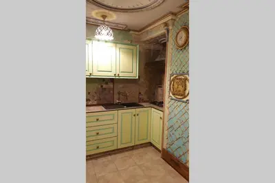 a kitchen with green cabinets and a clock on the wall at Beautiful one bedroom apartment in Vilnius old town in Vilnius