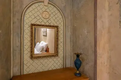 a mirror on a wall with a vase on a table at Beautiful one bedroom apartment in Vilnius old town in Vilnius