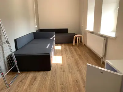 a room with a bed and a table and a chair at Žvejo krantas Palūšė in Palūšė