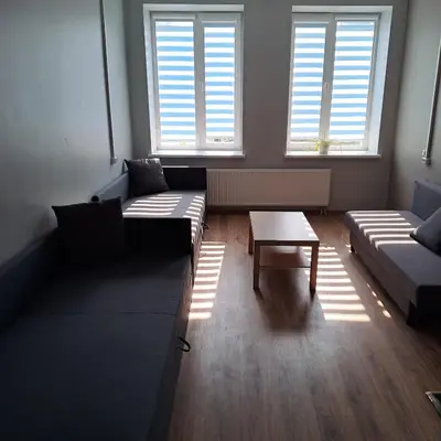 a living room with two couches and a table at Žvejo krantas Palūšė in Palūšė
