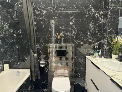 a black and white bathroom with a toilet and a tub at Editos Apartamentai in Vilnius