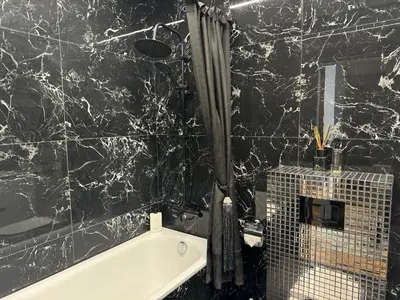 a black and white bathroom with a bath tub at Editos Apartamentai in Vilnius