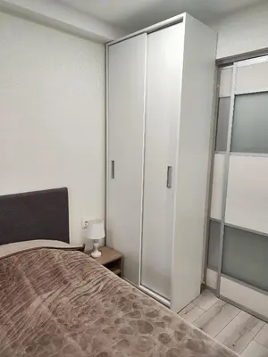 a bedroom with a bed and a glass closet at Monica Apartments in Panevėžys