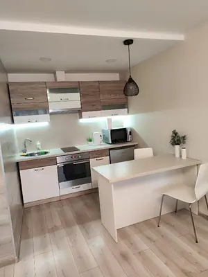 a kitchen with white cabinets and a white counter top at Monica Apartments in Panevėžys