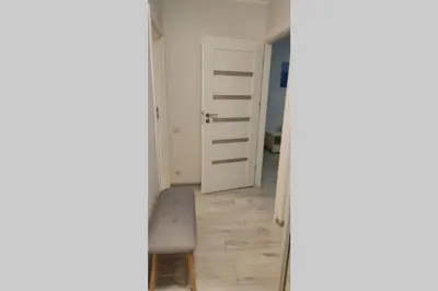 a hallway with a door and a chair in a room at Butas miesto centre/ Apartment in the city center in Šiauliai