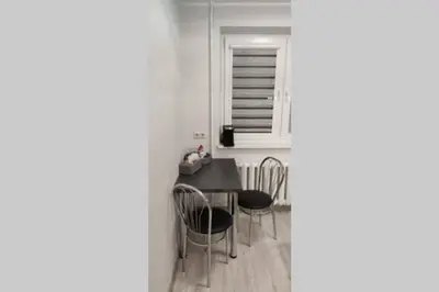 a dining room with a table and chairs and a window at Butas miesto centre/ Apartment in the city center in Šiauliai