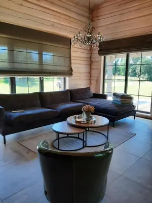 a living room with a couch and a table at Vila Saulė in Sudeikiai