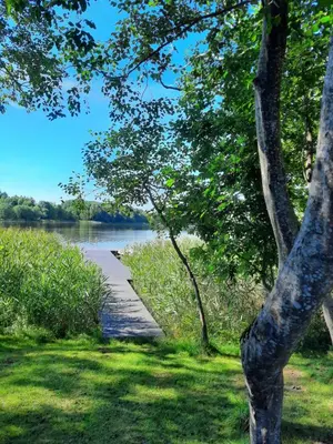 a path next to a body of water at Vila Saulė in Sudeikiai