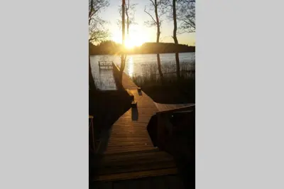 a wooden dock with the sunset in the background at Mėnulės pirtelė in Sudeikiai