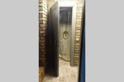 a bathroom with a shower with a glass door at Mėnulės pirtelė in Sudeikiai