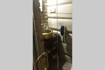 a bathroom with a sink and a wooden wall at Mėnulės pirtelė in Sudeikiai