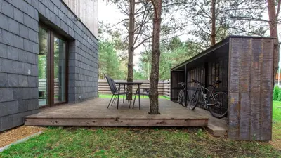 a wooden deck with a table and bikes on it at Don Vyto in Druskininkai