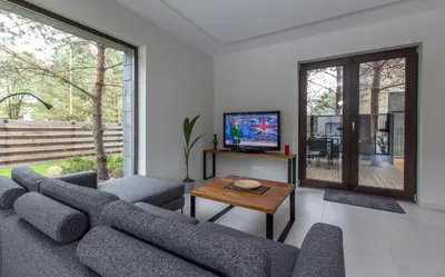 a living room with a couch and a tv at Don Vyto in Druskininkai
