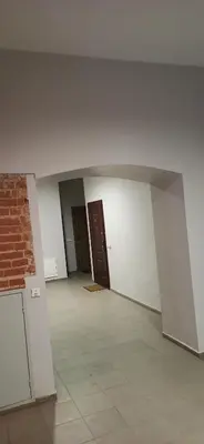 an empty room with two doors and a brick wall at Studio flat in a historical XIX c. building. in Kaunas