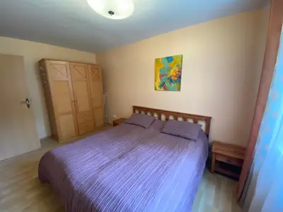 a bedroom with a bed with a purple comforter at Butas Senamiestyje in Druskininkai