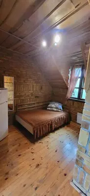 a bedroom with a bed in a room with a brick wall at Meškių dvarkiemis in Šiauliai