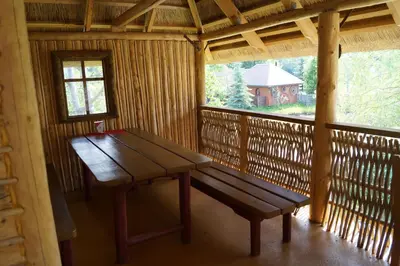 a wooden bench in a cabin with a window at Meškių dvarkiemis in Šiauliai