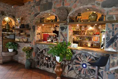 a bar in a stone building with a wheel at Meškių dvarkiemis in Šiauliai