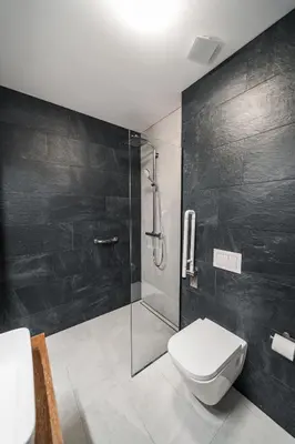 a bathroom with a toilet and a glass shower at Modern Apartment Next to Kaunas Castle in Kaunas