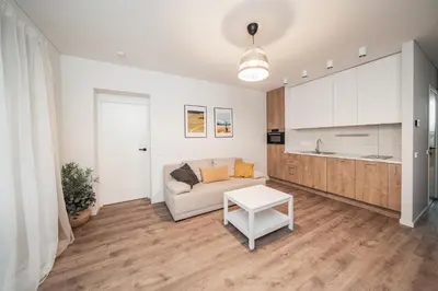a living room with a couch and a table at Modern Apartment Next to Kaunas Castle in Kaunas