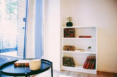 a room with a table and a book shelf with books at Modern Apartment Next to Kaunas Castle in Kaunas
