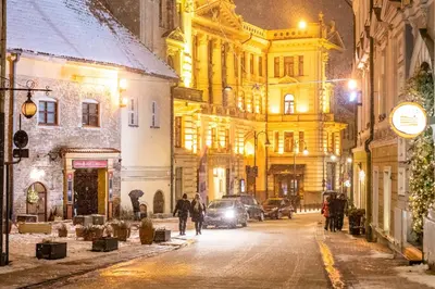 a city street at night with people walking down the street at COME2rest - Subaciaus 5 in Vilnius