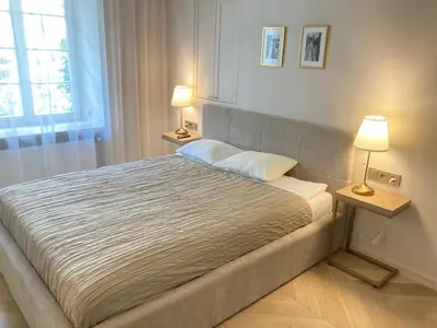 a bedroom with a large bed with two lamps at COME2rest - Subaciaus 5 in Vilnius