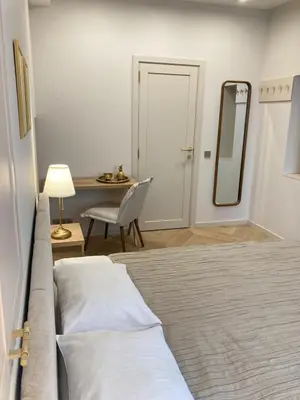 a bedroom with a bed and a table and a mirror at COME2rest - Subaciaus 5 in Vilnius