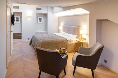 a hotel room with a bed and two chairs at COME2rest - Subaciaus 5 in Vilnius