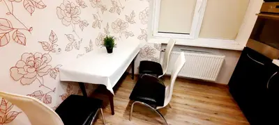 a table with chairs and a plant on a wall at M&M Apartment VIII Self CHECK-IN in Panevėžys