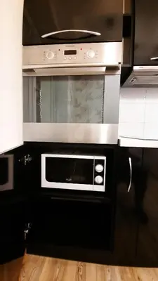 a microwave oven in a kitchen with black cabinets at M&M Apartment VIII Self CHECK-IN in Panevėžys