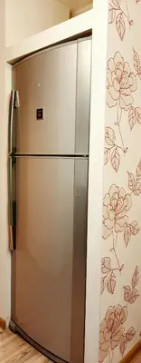 a stainless steel refrigerator in a kitchen with floral wallpaper at M&M Apartment VIII Self CHECK-IN in Panevėžys