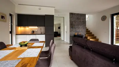 a kitchen and dining room with a table and chairs at Pine Home in Druskininkai