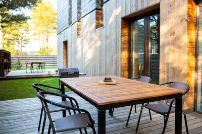 a wooden table and chairs on a patio at Pine Home in Druskininkai