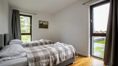 a bedroom with a bed and a large window at Pine Home in Druskininkai