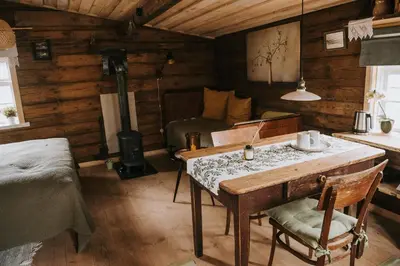 a room with a table and a bed in a cabin at Vienkiemio Oazė - Namelis Prie Šermukšnio in Galvokai