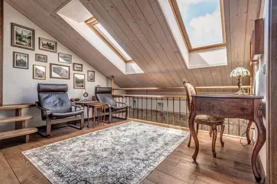 an attic room with a desk and chairs and a skylight at House of Nobles with personal terrace in Užupis in Vilnius