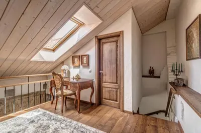 an attic room with a table and a skylight at House of Nobles with personal terrace in Užupis in Vilnius