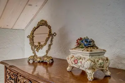 a table with a mirror and a vase on it at House of Nobles with personal terrace in Užupis in Vilnius
