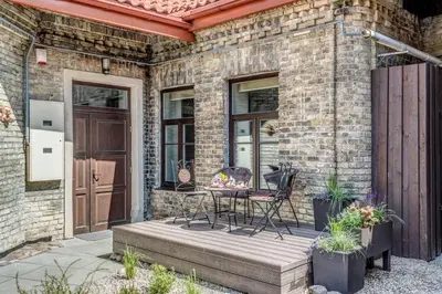 a patio with a table and chairs on a brick wall at House of Nobles with personal terrace in Užupis in Vilnius