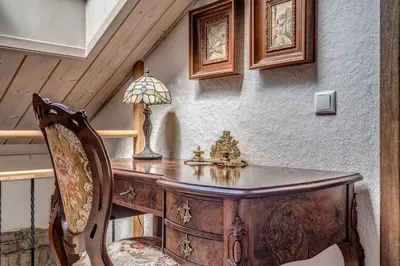 a wooden desk with a lamp and a chair at House of Nobles with personal terrace in Užupis in Vilnius