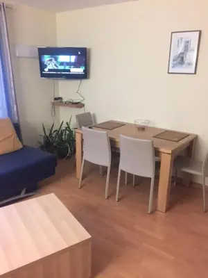 a living room with a table and chairs and a tv at Kęstučio 74 in Kaunas