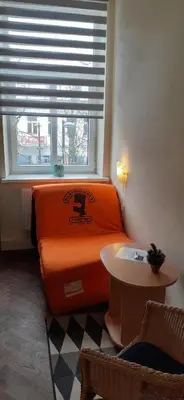 an orange bed in a room with a window at Attic rooms at Laisves avenue in Kaunas