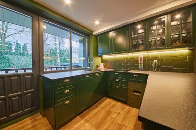 a green kitchen with green cabinets and windows at 